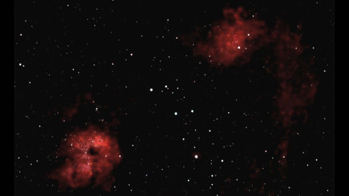 Two red clouds of gas in a field of stars: IC 405, the Flaming Star Nebula, at the top right, and IC 410 at the bottom left with a dark hollow at its centre.