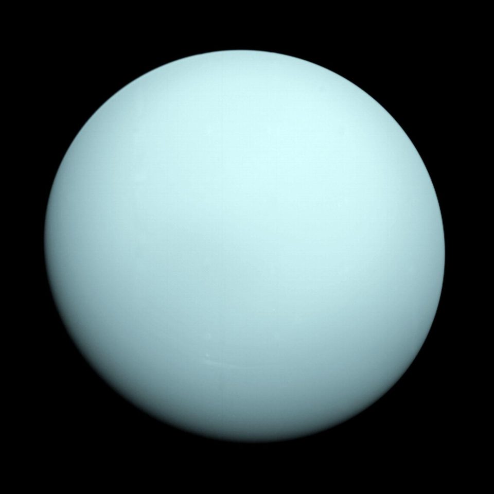 Uranus photographed by Voyager 2, an almost featureless pale blue green globe with no visible markings.
